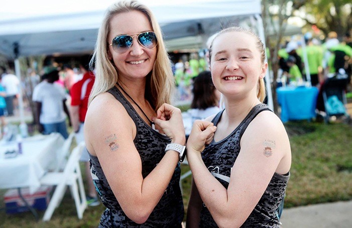 Team member and child showing off temporary tattoos