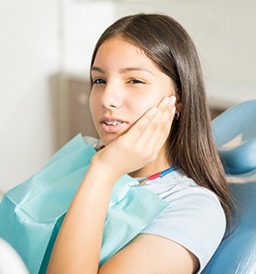 Teen with braces holding cheek