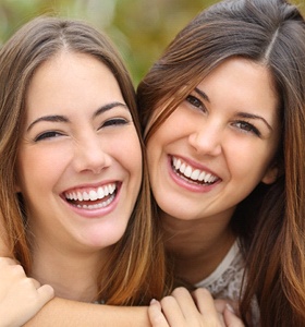 Two girls smiling and hugging