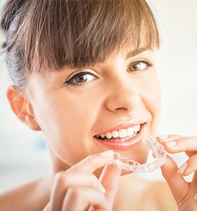 Woman placing Invisalign tray