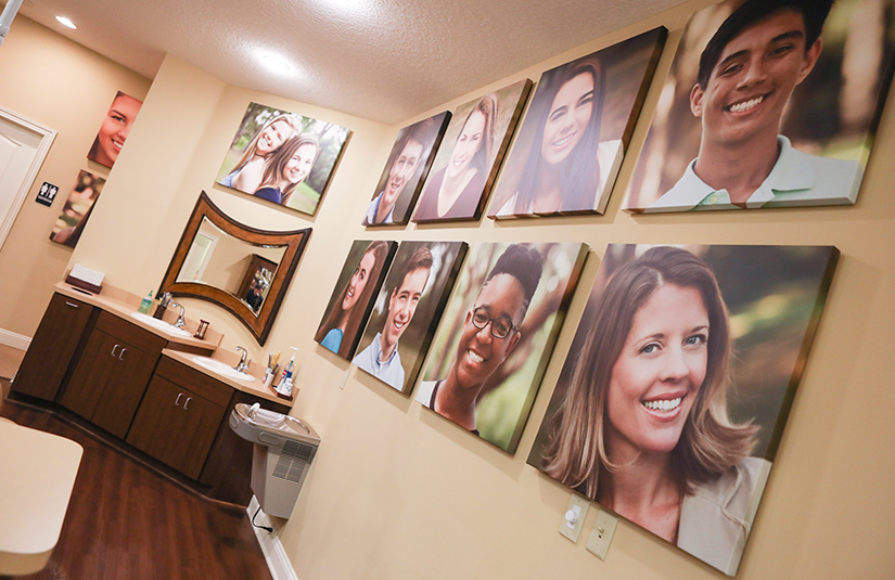 Real patient photos on orthodontic office wall