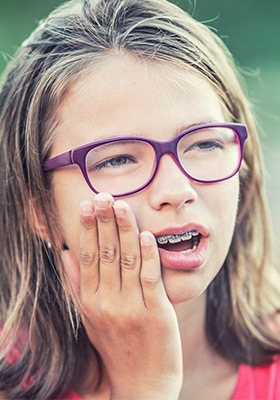 Girl with braces holding jaw