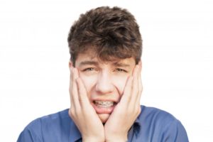 Young man with braces in pain