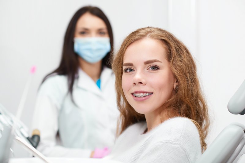 Girl with braces smiling at orthodontic appointment