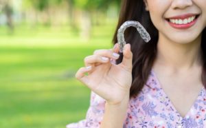 Closeup of smiling woman with Invisalign in Jacksonville outside