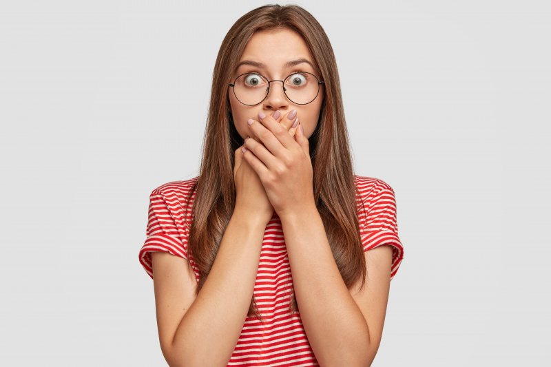 Closeup of woman covering her mouth in shock