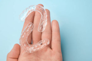 Hand holding clear aligners