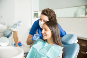 a dental assistant showing a patient their braces in a mirror